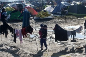 Children stand at the Greek-Macedonian border near the Greek village of Idomeni where thousands of refugees and migrants are trapped by the Balkan border blockade, on March 11, 2016. The German and Greek leaders blasted Balkan countries for shutting their borders to migrants ahead of an EU ministers meeting on March 10. Greek authorities said there were 41,973 asylum seekers in the country, including some 12,000 stuck at Idomeni on the closed Macedonian border.  / AFP / SAKIS MITROLIDIS