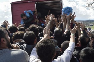 Migrants strech hands to grab supplies donated by Greek people on March 11, 2016, in a makeshift camp at the Greek-Macedonian border, near the Greek village of Idomeni, where thousands of refugees and migrants are stranded by the Balkan border blockade. The main migrant trail from Greece to northern Europe was blocked March 9 after western Balkan nations slammed shut their borders, hiking pressure for an EU-Turkey deal and exacerbating a dire situation on the Macedonian border. More than 14,000 mainly Syrian and Iraqi refugees are camping out by the northern Idomeni border crossing with Macedonia -- many of them for weeks -- at a muddy, unhygienic camp operated by beleaguered aid groups.  / AFP / DANIEL MIHAILESCU