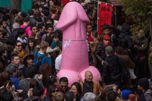 KAWASAKI, JAPAN - APRIL 06:  People pose for photos in front of a large pink phallic-shaped 'Mikoshi'  during Kanamara Matsuri (Festival of the Steel Phallus) on April 6, 2014 in Kawasaki, Japan. The Kanamara Festival is held annually on the first Sunday of April. The penis is the central theme of the festival, focused at the local penis-venerating shrine which was once frequented by prostitutes who came to pray for business prosperity and protection against sexually transmitted diseases. Today the festival has become a popular tourist attraction and is used to raise money for HIV awareness and research.  (Photo by Chris McGrath/Getty Images)