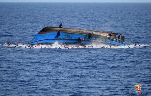 People jump out of a boat right after overturning off the Libyan coast, Wednesday, May 25, 2016. The Italian navy says it has recovered 7 bodies from the overturned migrant ship off the coast of Libya. Another 500 migrants who on board were rescued safely. (Marina Militare via AP Photo)