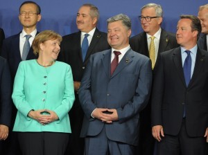 German Chancellor Angela Merkel shares a laugh with Ukraine's president Petro Poroshenko as British Prime Minister David Cameron watches at the NATO summit in Warsaw, Poland, Friday, July 8, 2016. Starting Friday, US President Barack Obama and leaders of the 27 other NATO countries will take decisions in Warsaw on how to deal with a resurgent Russia, violent extremist organizations like Islamic State, attacks in cyberspace and other menaces to allies' security during a summit described by many observers as NATO's most crucial meeting since the 1989 fall of the Berlin Wall.(AP Photo/Alik Keplicz)