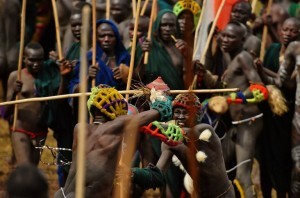 Men from the Suri tribe take part in a "Donga" or stick fight in Ethiopia's southern Omo Valley region near Kibbish on September 24, 2016.  Traditionally the fight is a way to impress women and find a wife. The fights are brutal and sometimes result in death. The combatants fight with little or no clothing and sometimes no protection at all. The Suri are a pastoralist Nilotic ethnic group in Ethiopia. The construction of the Gibe III dam, the third largest hydroelectric plant in Africa, and large areas of very "thirsty" cotton and sugar plantations and factories along the Omo river are impacting heavily on the lives of tribes living in the Omo Valley who depend on the river for their survival and way of life. Human rights groups fear for the future of the tribes if they are forced to scatter, give up traditional ways through loss of land or ability to keep cattle as globalisation and development increases.  / AFP PHOTO / CARL DE SOUZA