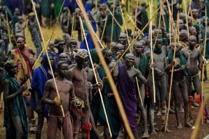 Men from the Suri tribe take part in a "Donga" or stick fight in Ethiopia's southern Omo Valley region near Kibbish on September 24, 2016.  Traditionally the fight is a way to impress women and find a wife. The fights are brutal and sometimes result in death. The combatants fight with little or no clothing and sometimes no protection at all. The Suri are a pastoralist Nilotic ethnic group in Ethiopia. The construction of the Gibe III dam, the third largest hydroelectric plant in Africa, and large areas of very "thirsty" cotton and sugar plantations and factories along the Omo river are impacting heavily on the lives of tribes living in the Omo Valley who depend on the river for their survival and way of life. Human rights groups fear for the future of the tribes if they are forced to scatter, give up traditional ways through loss of land or ability to keep cattle as globalisation and development increases.  / AFP PHOTO / CARL DE SOUZA