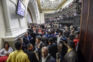 Members of the National Assembly react as supporters of Venezuelan President Nicolas Maduro force their way during an extraordinary session called by opposition leaders, in Caracas on October 23, 2016.  The opposition Democratic Unity Movement (MUD) called a Parliamentary session to debate putting President Nicolas Maduro on trial to "restore democracy" in an emergency session that descended into chaos as supporters of the leftist leader briefly seized the chamber. / AFP PHOTO / JUAN BARRETO