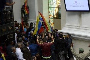 Supporters of Venezuelan President Nicolas Maduro force their way to the National Assembly during an extraoridinary session called by opposition leaders, in Caracas on October 23, 2016.  The opposition Democratic Unity Movement (MUD) called a Parliamentary session to debate putting President Nicolas Maduro on trial to "restore democracy" in an emergency session that descended into chaos as supporters of the leftist leader briefly seized the chamber. / AFP PHOTO / FEDERICO PARRA