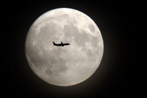 A commerical jet flies in front of the moon on its approach to Heathrow airport in west London on November 13, 2016. Tomorrow, the moon will orbit closer to the earth than at any time since 1948, named a 'supermoon', it is defined by a Full or New moon coinciding with the moon's closest approach to the Earth. / AFP PHOTO / Adrian DENNIS