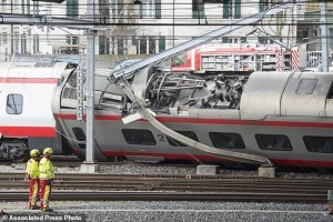 Rescuers stand next to a derailed train in the station of Lucerne, Switzerland, Wednesday, March 22,  2017. Swiss police say they are trying to reach people trapped inside the train in the  city of Lucerne, with details of any injuries still unclear. Rail company SBB says the Milan to Basel train derailed Wednesday as it was pulling out of Lucerne’s main train station.   (Urs Flueeler/Keystone via AP)