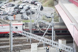 Rescuers stand next to a derailed train in the train station of Lucerne, Switzerland, Wednesday, March 22, 2017. Swiss police say they are trying to reach people trapped inside the train, with details of any injuries still unclear. Rail company SBB says the Milan to Basel train derailed Wednesday as it was pulling out of Lucerne’s main train station. (Urs Flueeler/Keystone via AP)