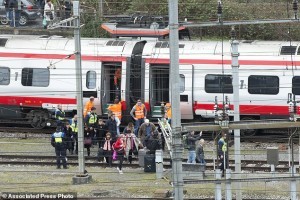 Rescuers stand next to a derailed train and help some passengers in the train station of Lucerne, Switzerland, Wednesday, March 22,  2017. Swiss police say they are trying to reach people trapped inside the train, with details of any injuries still unclear. Rail company SBB says the Milan to Basel train derailed Wednesday as it was pulling out of Lucerne’s main train station.   (Urs Flueeler/Keystone via AP)