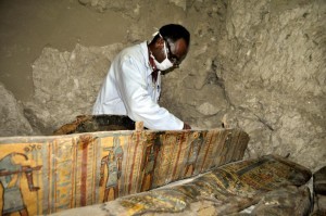 A member of an Egyptian archaeological team works on a wooden coffin discovered in a 3,500-year-old tomb in the Draa Abul Nagaa necropolis, near the southern Egyptian city of Luxor, on April 18, 2017. Egyptian archaeologists have discovered six mummies, colourful wooden coffins and more than 1,000 funerary statues in the 3,500-year-old tomb, the antiquities ministry said. / AFP PHOTO / STRINGER
