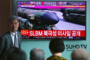 People watch a television news broadcasting live footage of a parade to mark the 105th anniversary of the birth of North Korea's founder Kim Il-Sung, at a railway station in Seoul on April 15, 2017. North Korean leader Kim Jong-Un on April 15 saluted as ranks of goose-stepping soldiers followed by tanks and other military hardware paraded in Pyongyang for a show of strength with tensions mounting over his nuclear ambitions. / AFP PHOTO / JUNG Yeon-Je