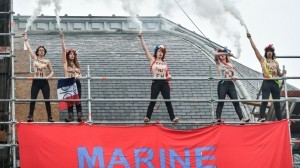 Members of feminist activist group Femen hold flares after unveiling a banner on a church in Henin-Beaumont, north-western France, to protest against French presidential election candidate for the far-right Front National (FN - National Front) party Marine Le Pen on May 7, 2017, during the second round of the Presidential election. / AFP PHOTO / Denis Charlet