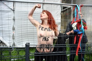Police arrest a member of feminist activist group Femen after unveiling a banner on a church in Henin-Beaumont, north-western France, to protest against French presidential election candidate for the far-right Front National (FN - National Front) party Marine Le Pen on May 7, 2017, during the second round of the French presidential election. / AFP PHOTO / ALAIN JOCARD