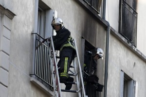 Firefighters work at the scene where a fire in an apartment building in the Myrha street, north of Paris, killed eight people early on September 2, 2015. A fire in an apartment building in northern Paris early Wednesday that killed eight people, including two children, might have been started intentionally, officials said. The blaze in the 18th district of the French capital, at the foot of the Montmartre hill and its tourist attractions, took more than 100 firefighters to contain it. AFP PHOTO / KENZO TRIBOUILLARD / AFP PHOTO / KENZO TRIBOUILLARD