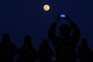 epaselect epa06487617 People gather to watch a so-called 'Supermoon' rising in Beijing, China, 31 January 2018, during the last time in a series of three consecutive 'Supermoons', dubbed the 'Supermoon Trilogy'. 03 December 2017 and on 01 January 2018. A 'Supermoon' commonly is described as a full moon at its closest distance to the earth with the moon appearing larger and brighter than usual.  EPA/WU HONG