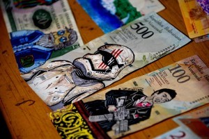 View of devalued Bolivar bills painted by Venezuelan illustrator Jose Leon at his workshop in San Cristobal, Venezuela on February 2, 2018. Using devalued Bolivar bills as raw material, this Venezuelan young artist found the way to make a living, increasing the value of the currency up to 5000%, by selling his artworks to foreign customers. / AFP PHOTO / GEORGE CASTELLANOS / TO GO WITH AFP STORY by Margioni BERMUDEZ
