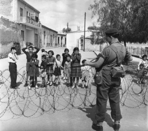 7th April 1956:  The net closes on EOKA terrorists in the mountainous districts of Cyprus, as a British Marine guards the road and bewildered children look on. The move follows the failure of intergovernmental talks over the future of the territory. Original Publication: Picture Post  - 8314 - Terrorist Hunt In Cyprus - pub.1956  (Photo by Bert Hardy/Picture Post/Getty Images)