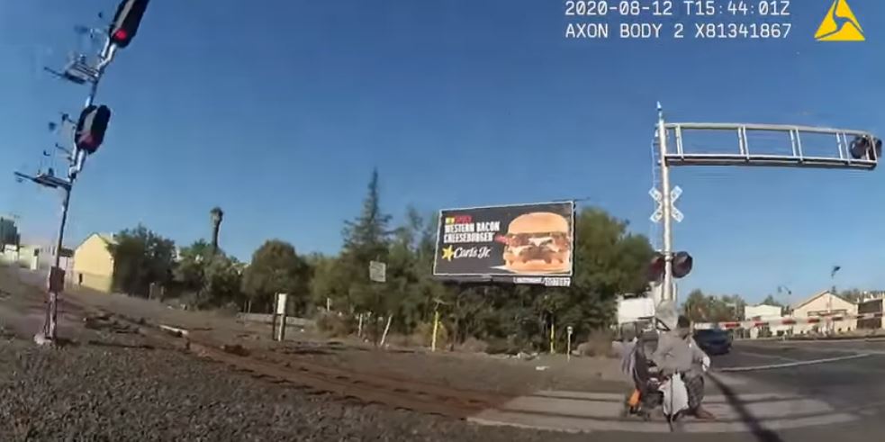 Heroic officer saves man in wheelchair from being run over by train ...